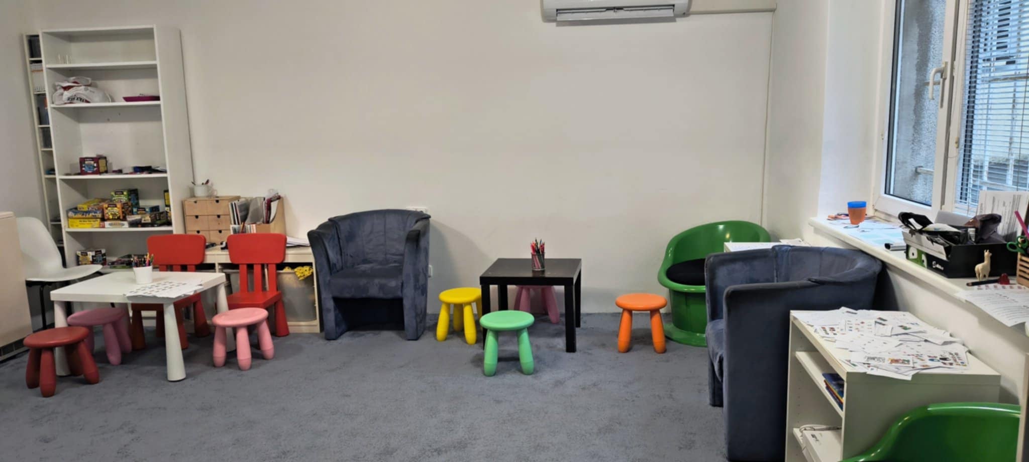 Místnost s křesly a barevnými stoličkami